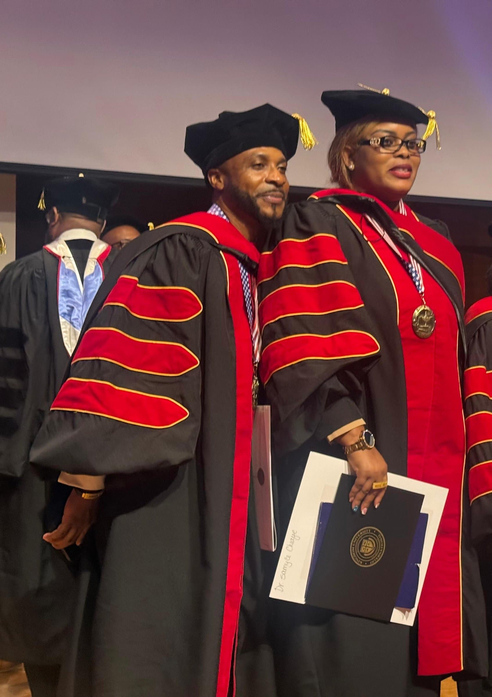 Dr. Davis and Prophetess Dr. Cheaye in doctoral robes on stage